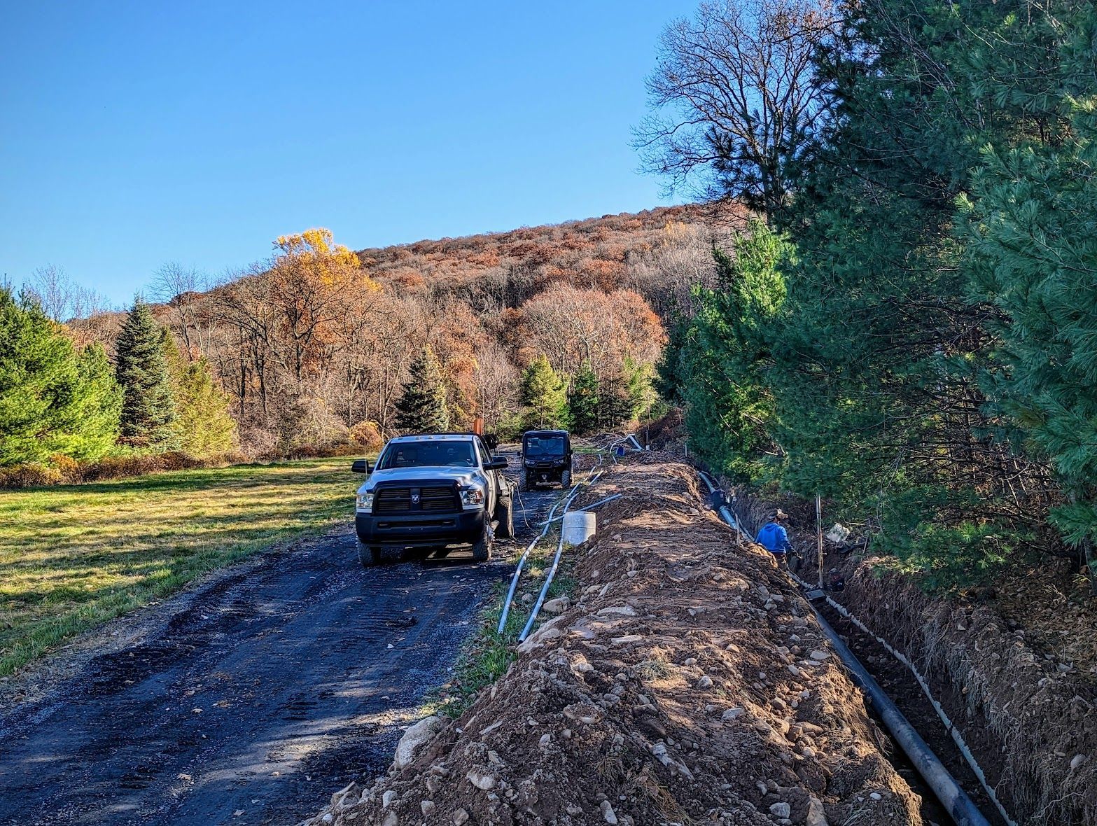 A truck is parked on the side of a dirt road.