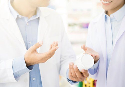 due farmaciste con una confezione di medicine in mano