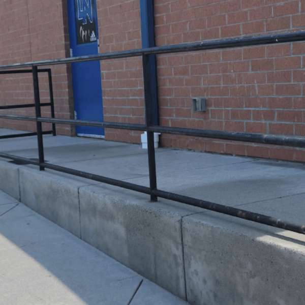 a brick building with a blue door and a black railing