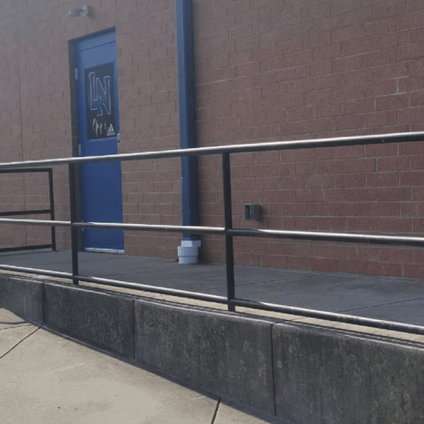 a brick building with a blue door and a metal railing
