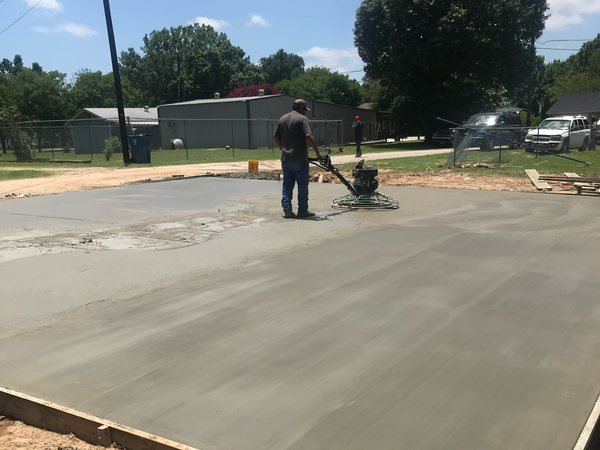 a man is using a machine to finish a concrete surface .