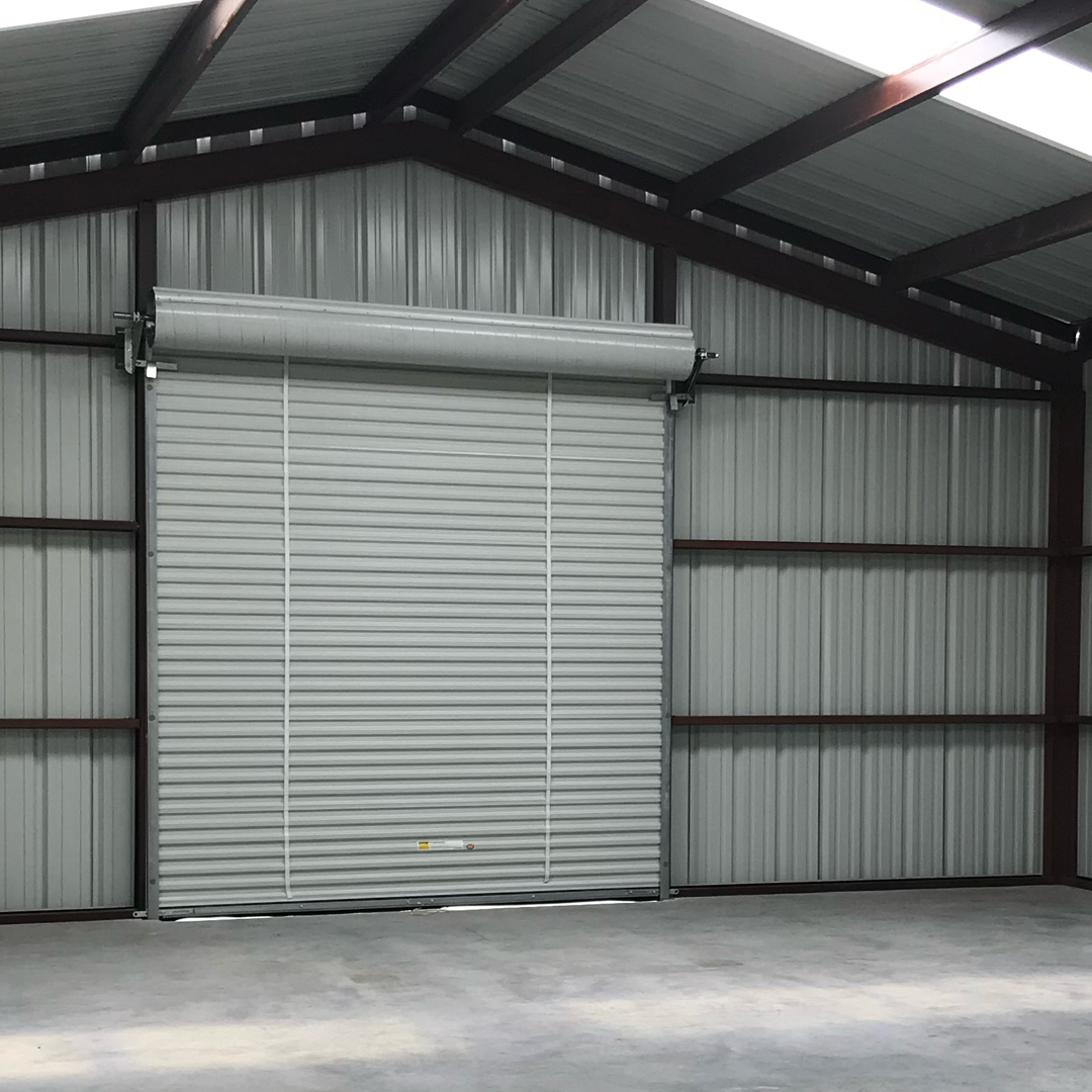 an empty warehouse with a roll up garage door