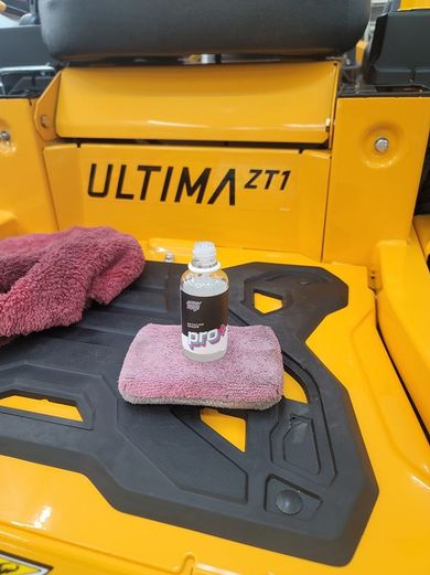 A yellow lawn mower with the word ultima zt1 on the back