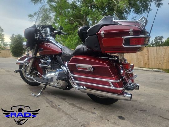 A red harley davidson motorcycle is parked on the side of the road.