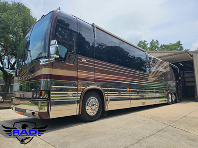 A large bus is parked in front of a garage.