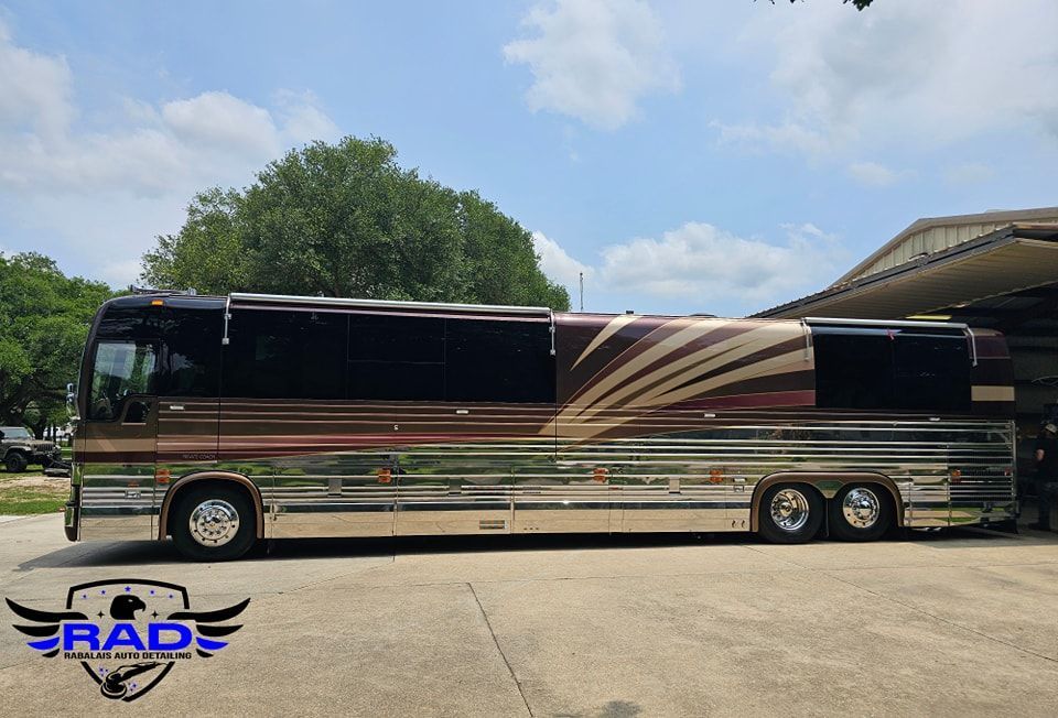 A large bus is parked in a parking lot in front of a building.
