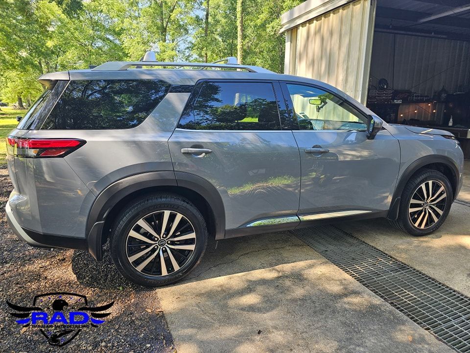 A nissan pathfinder is parked in front of a garage.