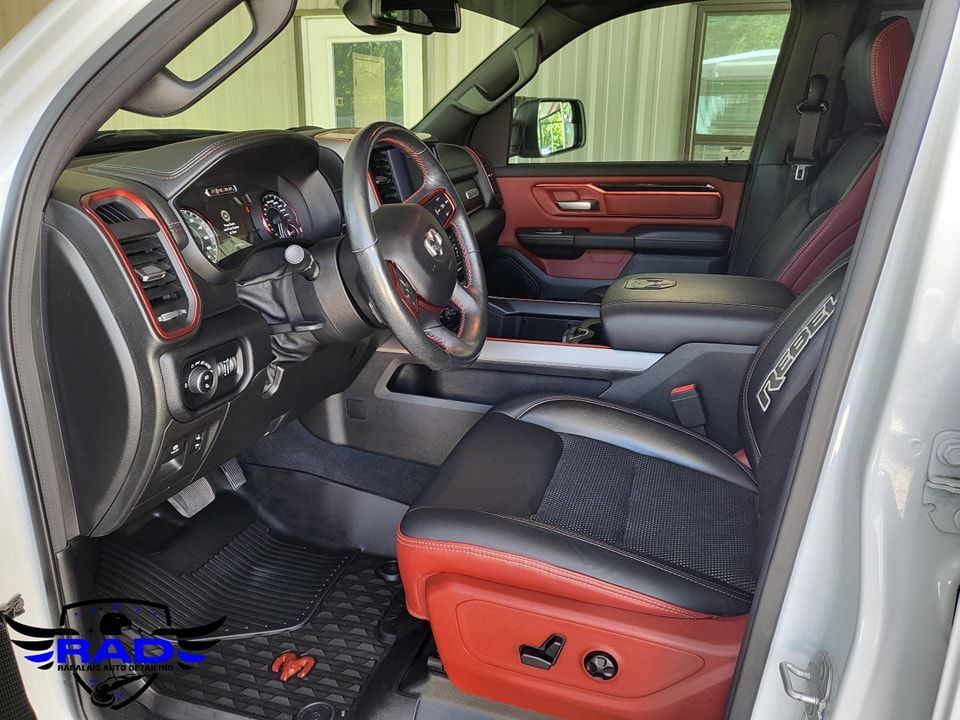 The interior of a silver ram truck with red seats