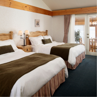 A hotel room with two beds and a sliding glass door