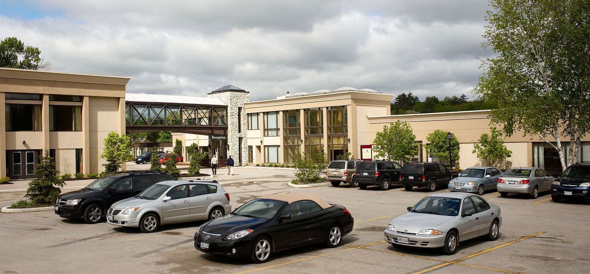 A row of cars are parked in front of a building
