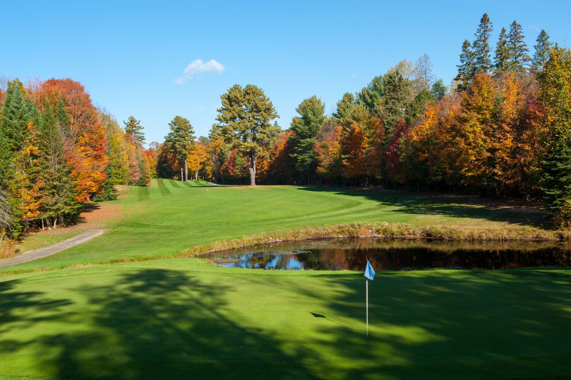 A golf course with a pond in the middle of it