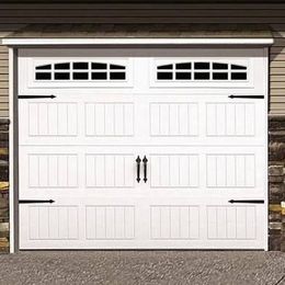 A white garage door with black handles is sitting next to a stone wall.