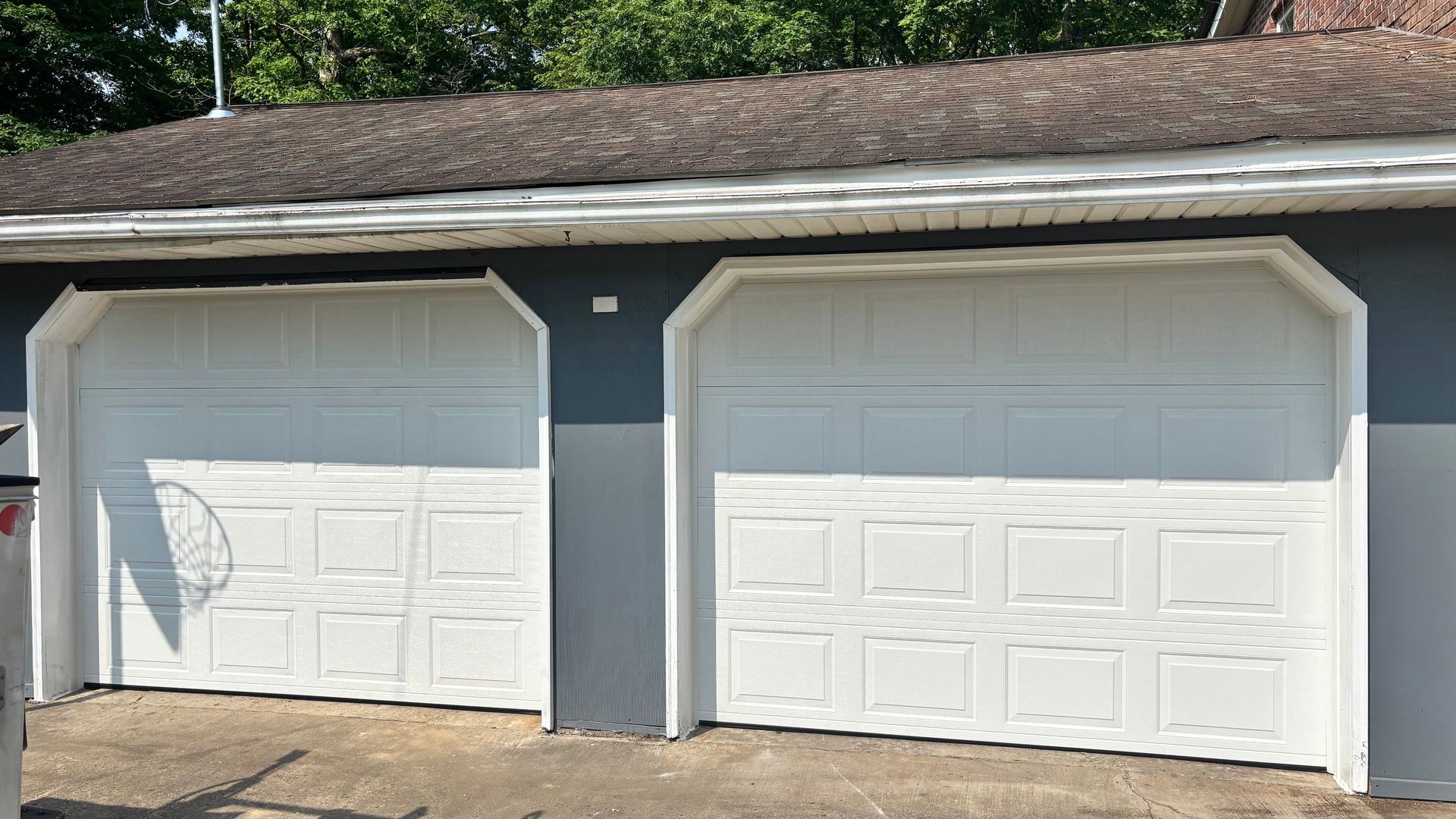 There are two garage doors on the side of a house.
