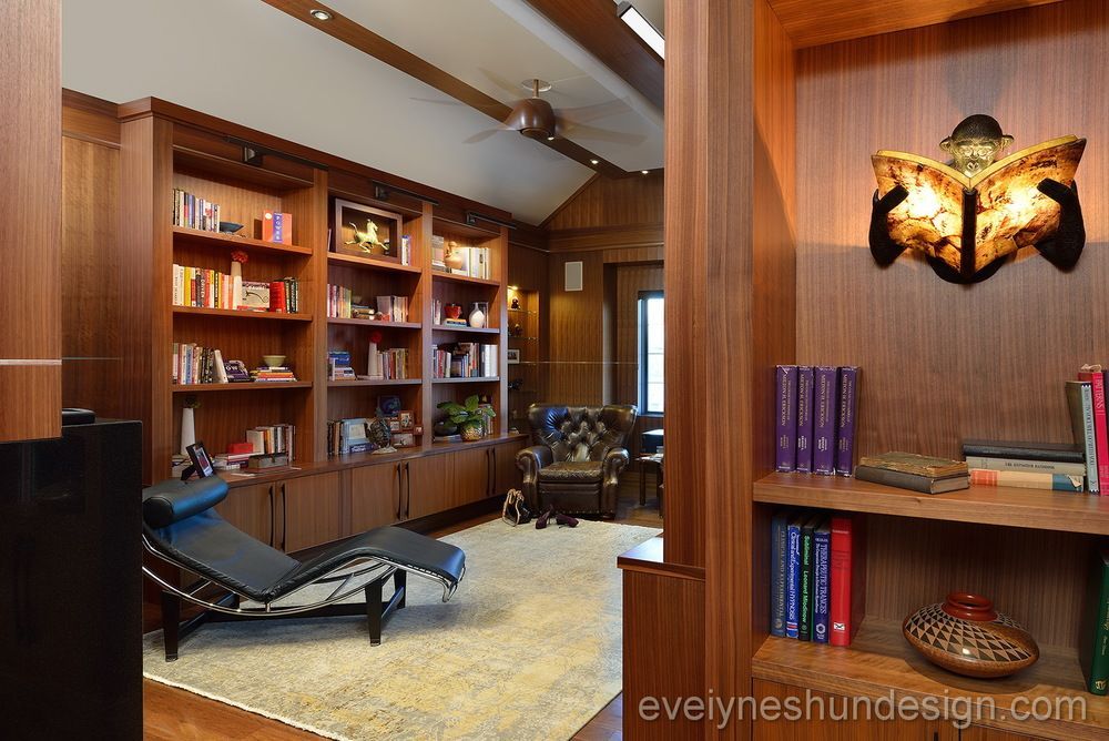 A living room with lots of bookshelves and a chair