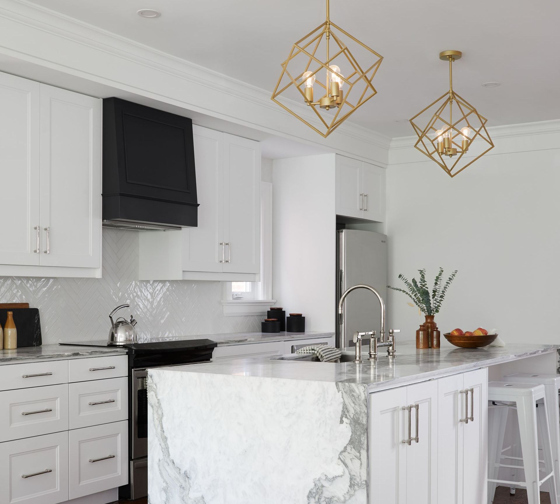 A kitchen with white cabinets and a large marble island.