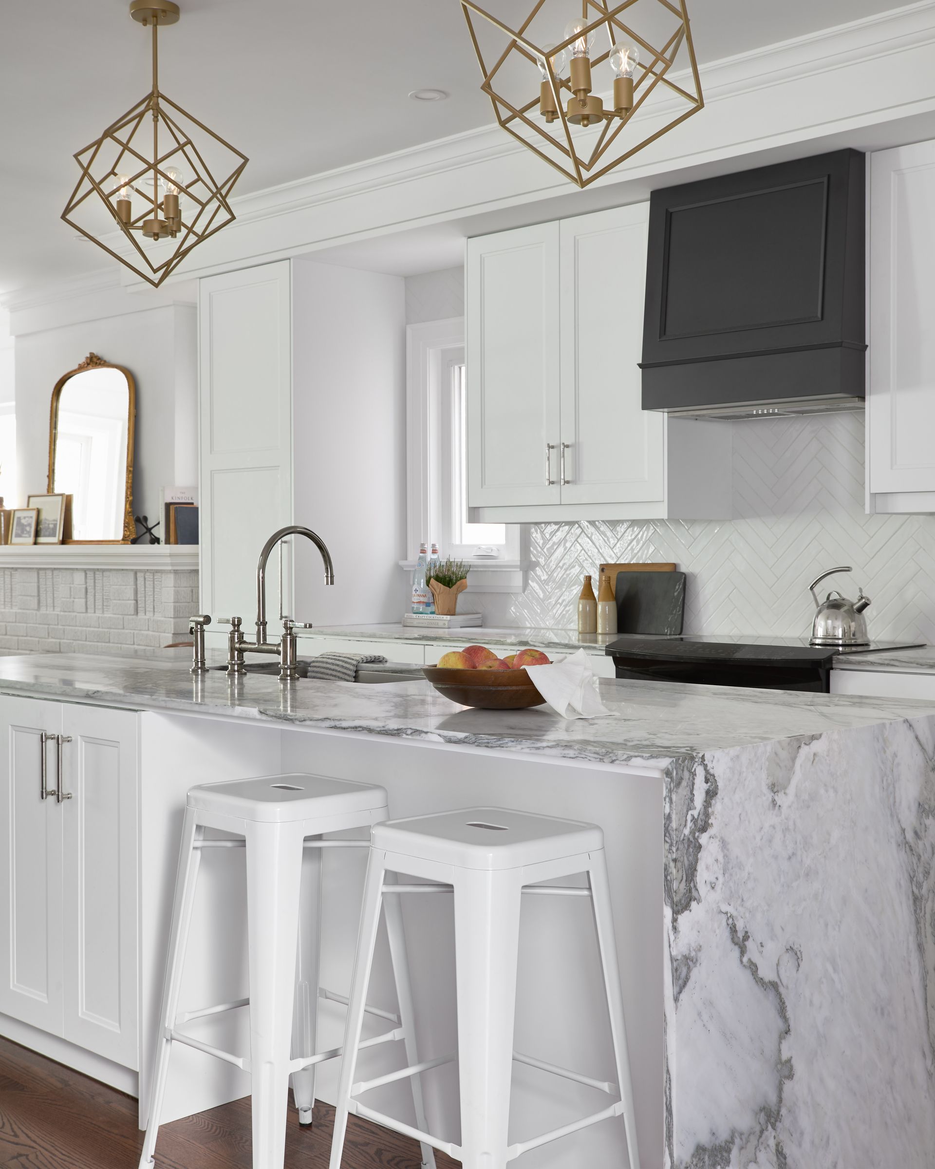 A kitchen with white cabinets and marble counter tops