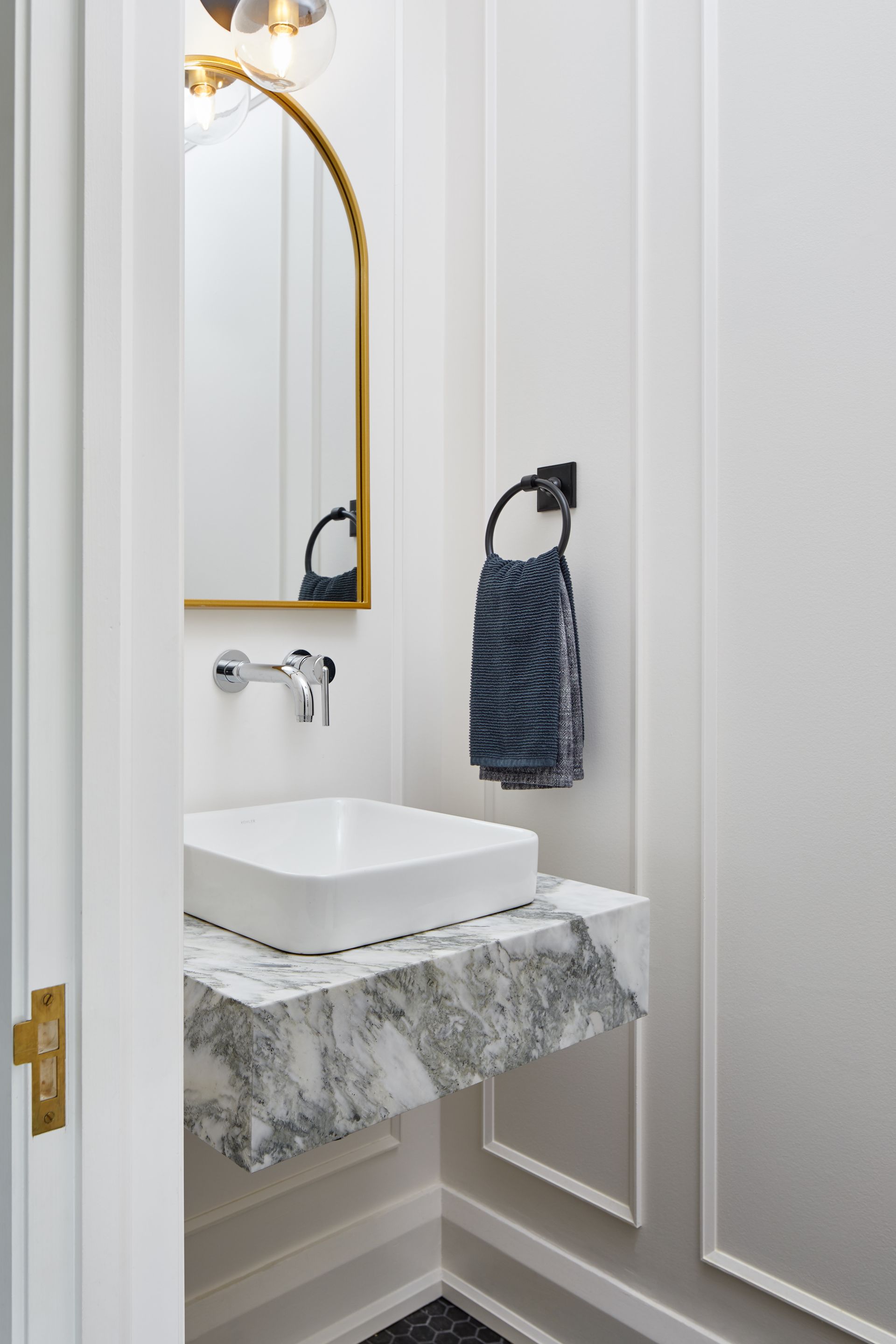 A bathroom with a sink , mirror and towel rack.