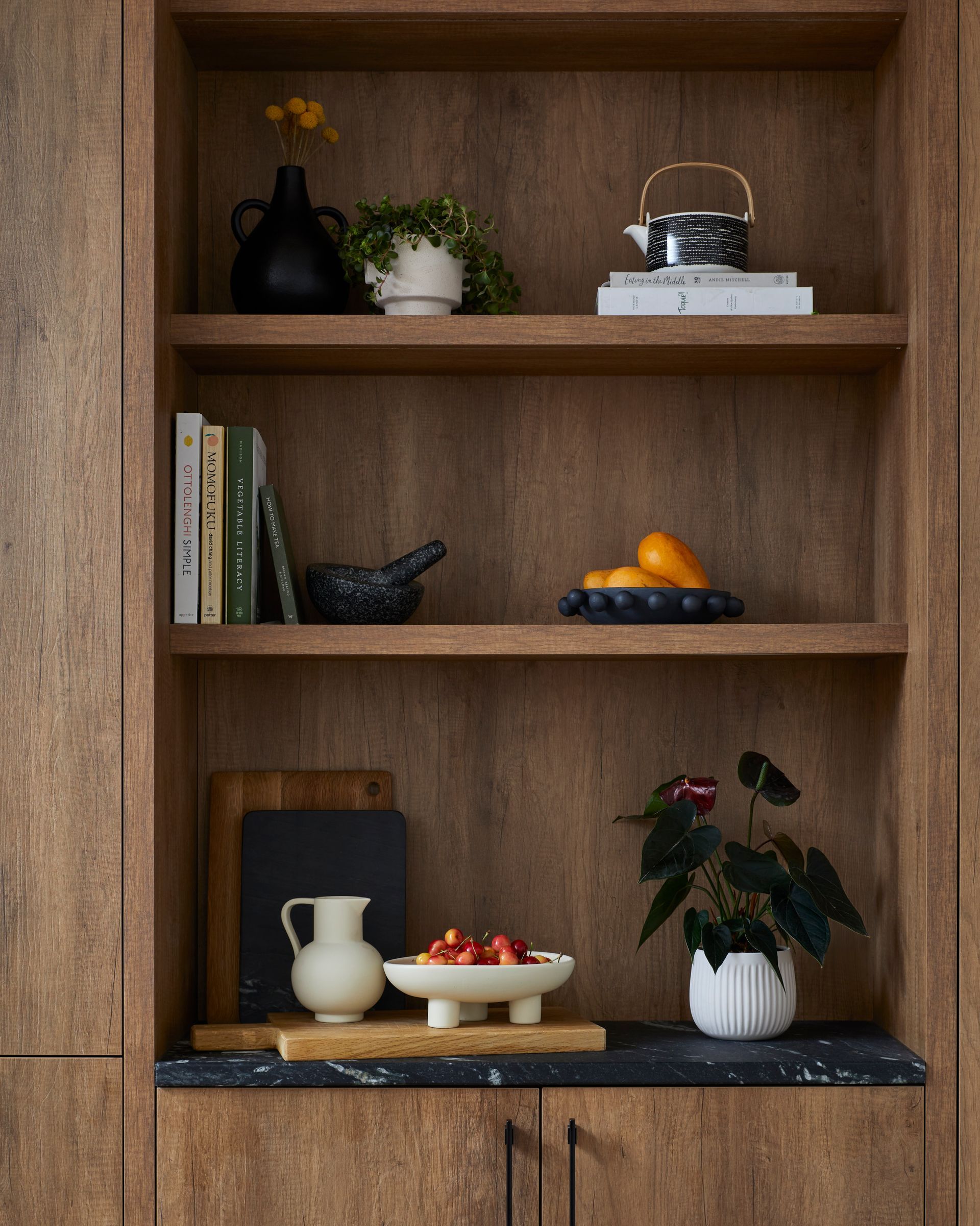 A wooden shelf with a bowl of strawberries on it