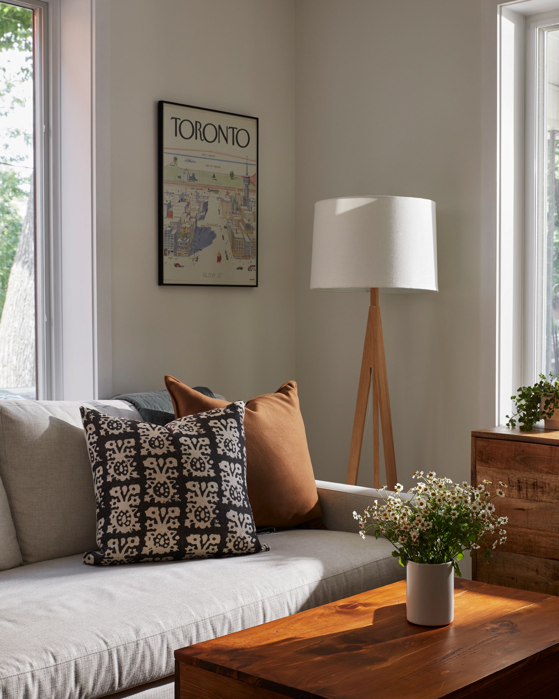 A living room with a couch and a lamp and a picture on the wall that says toronto