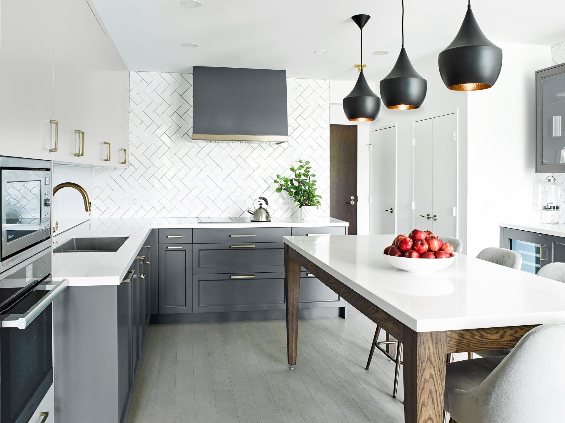 A kitchen with gray cabinets and white counter tops