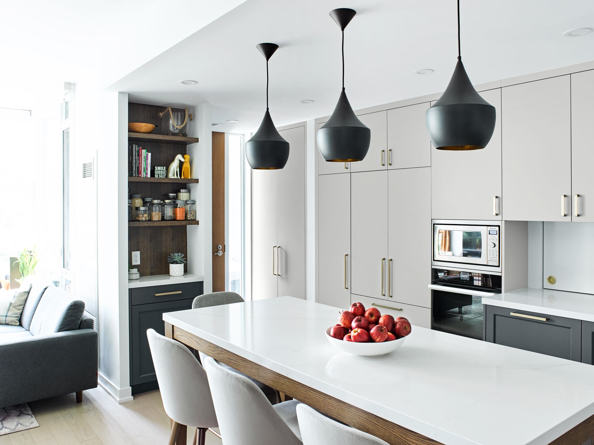 A kitchen with a large island and a bowl of apples on it