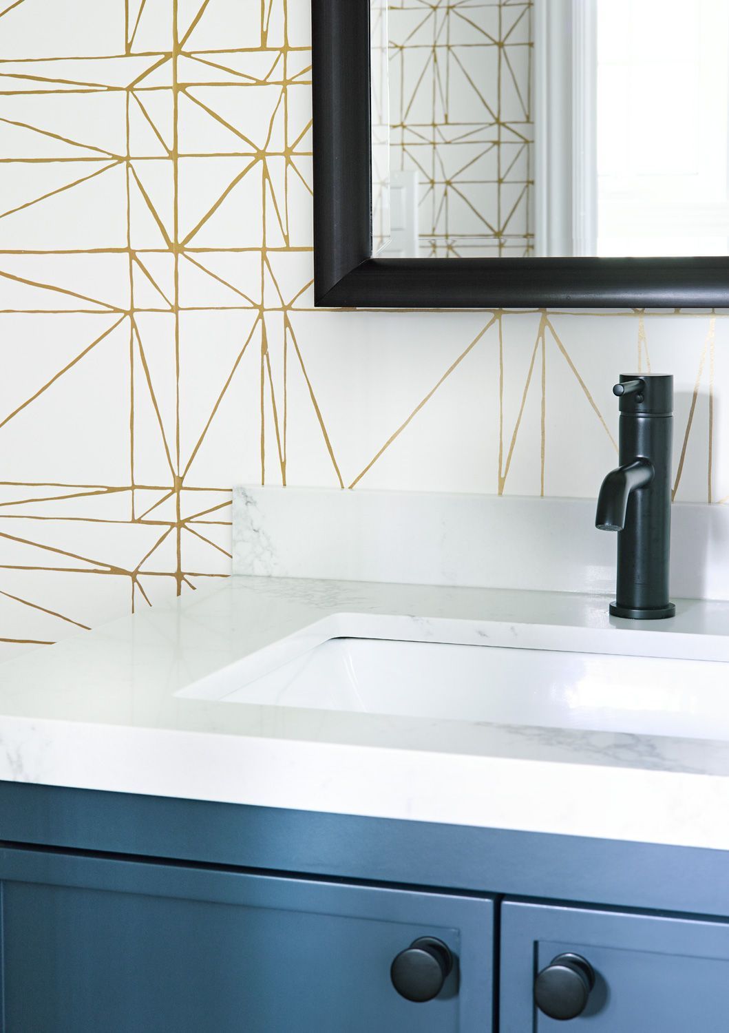 A bathroom sink with a black faucet and a mirror