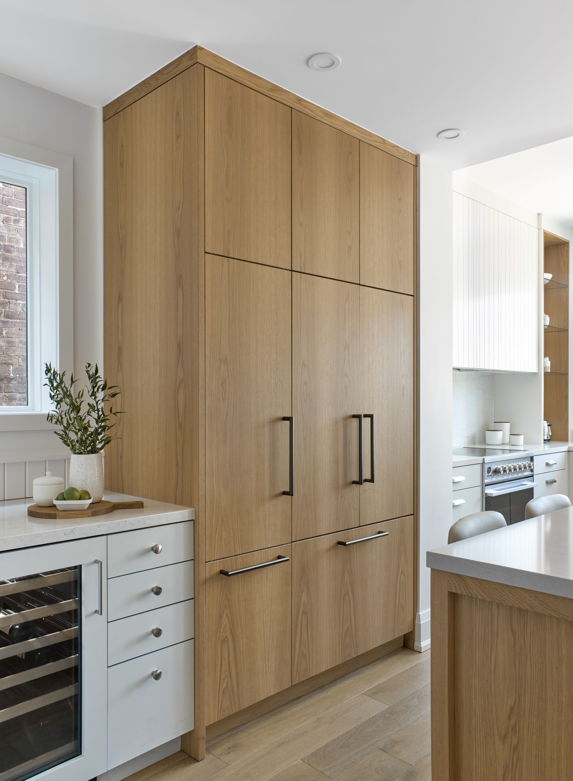 A kitchen with wooden cabinets and a wine cooler