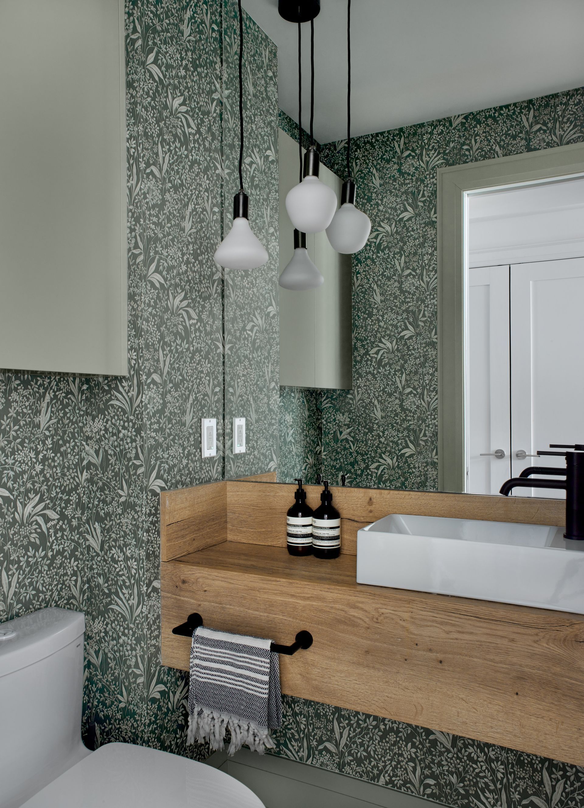 A bathroom with a sink , toilet and mirror.