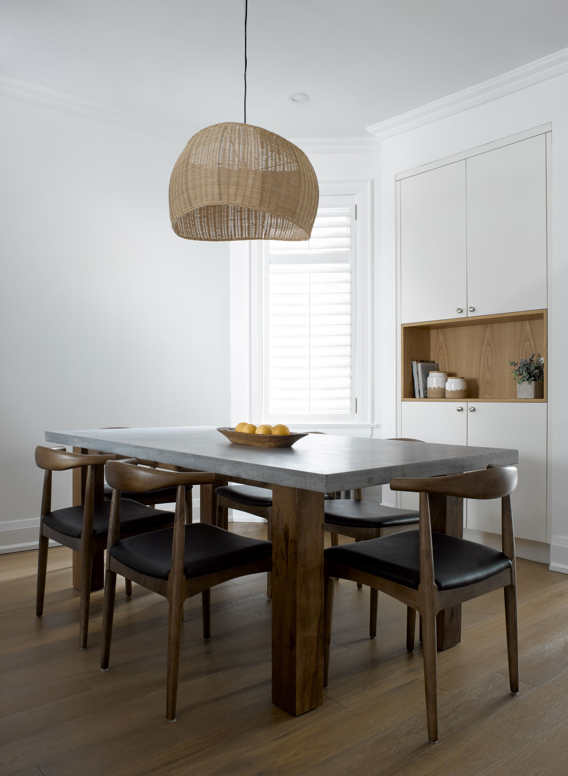 A dining room with a table and chairs and a pendant light