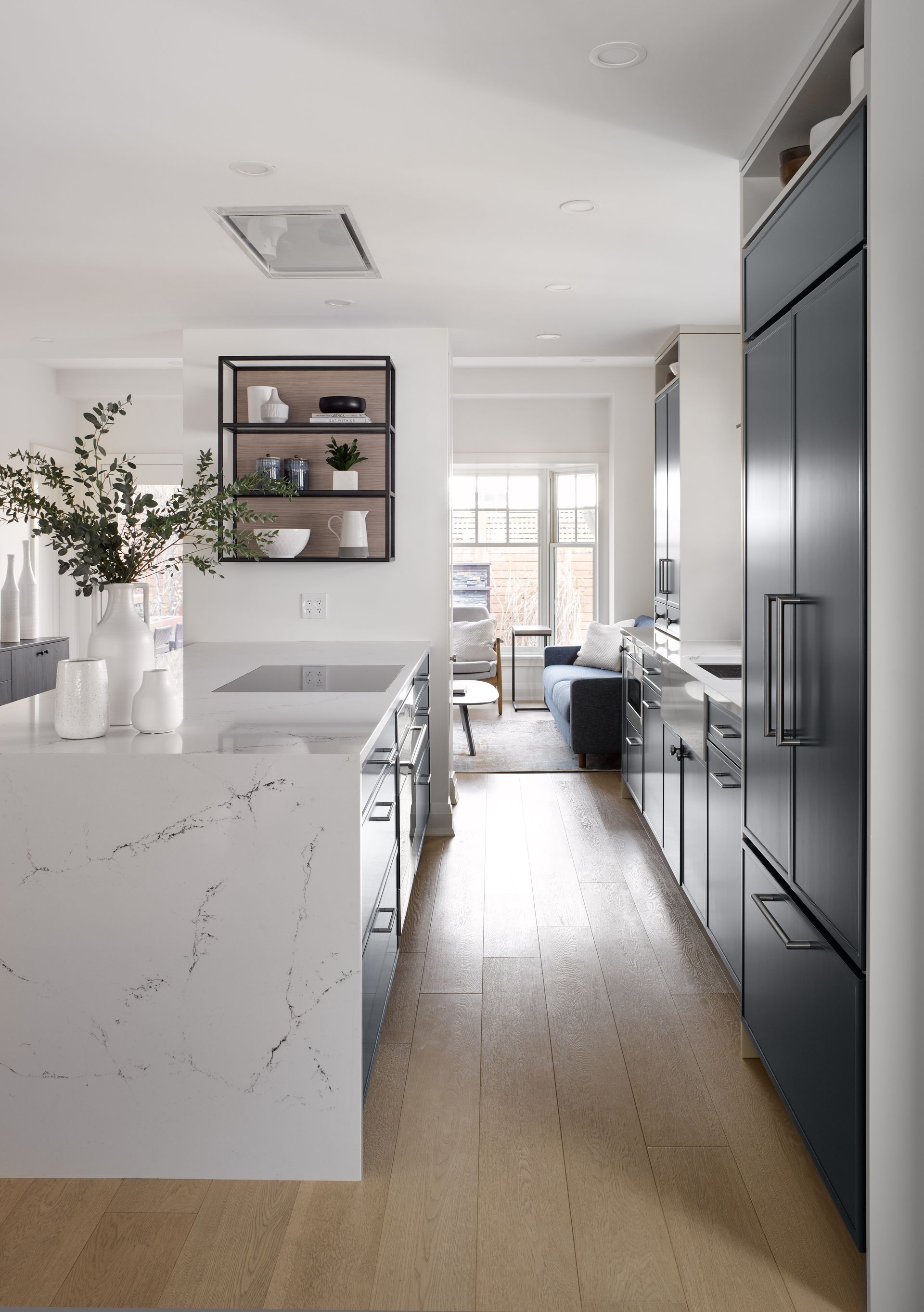 A kitchen with a white counter top and a black refrigerator.