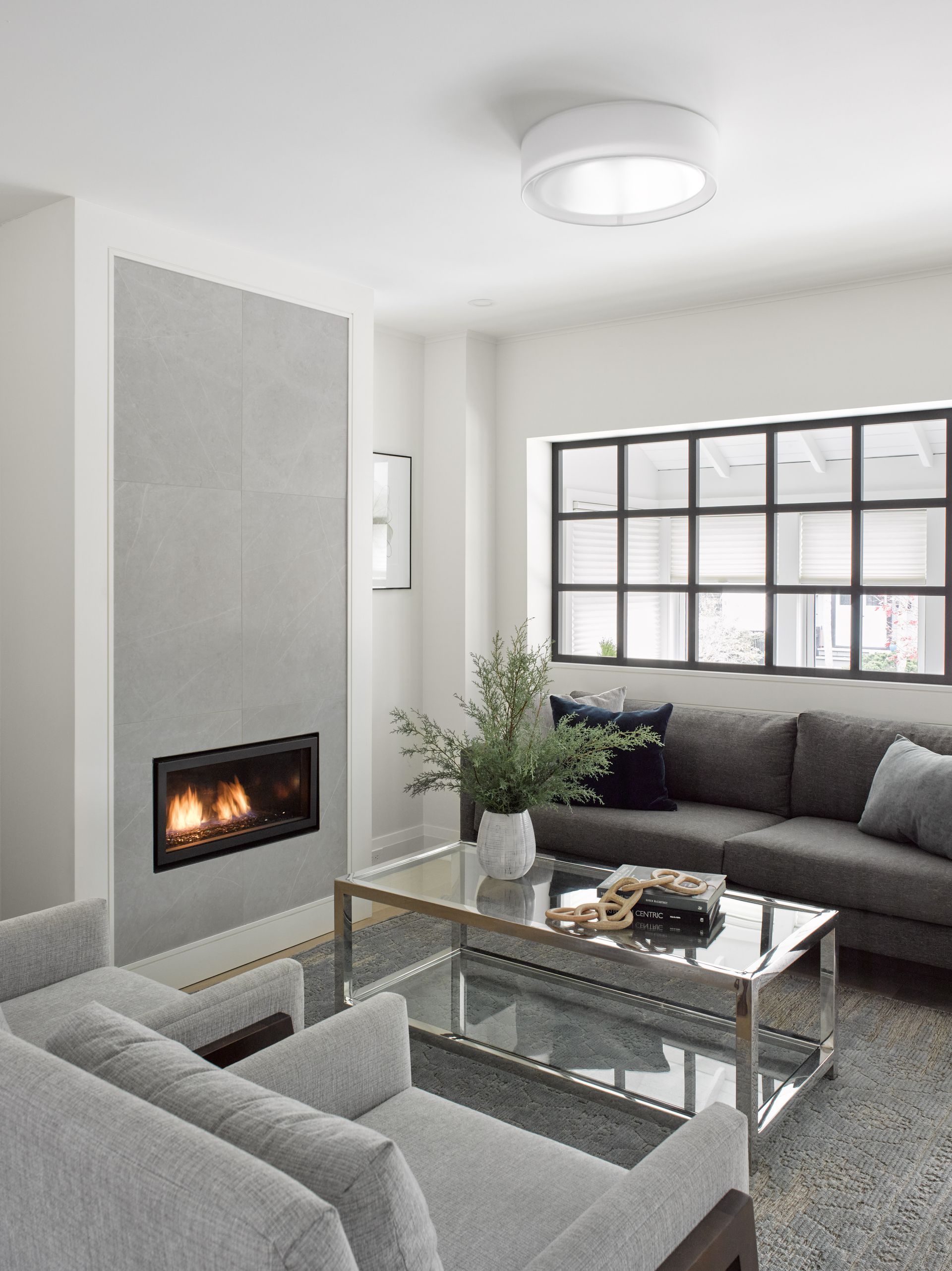 A living room with a couch , chair , coffee table and fireplace.