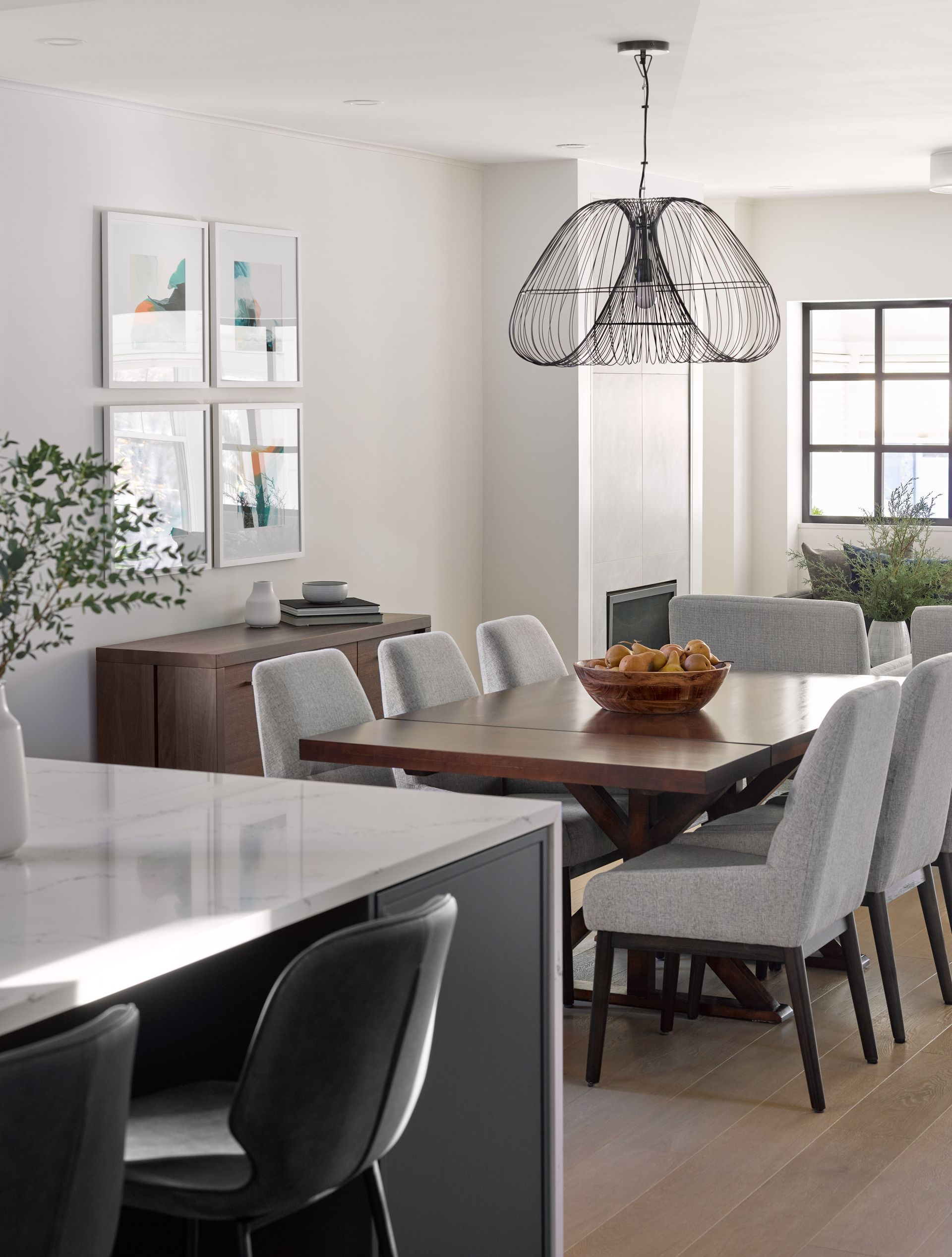 A dining room with a table and chairs and a chandelier hanging from the ceiling.