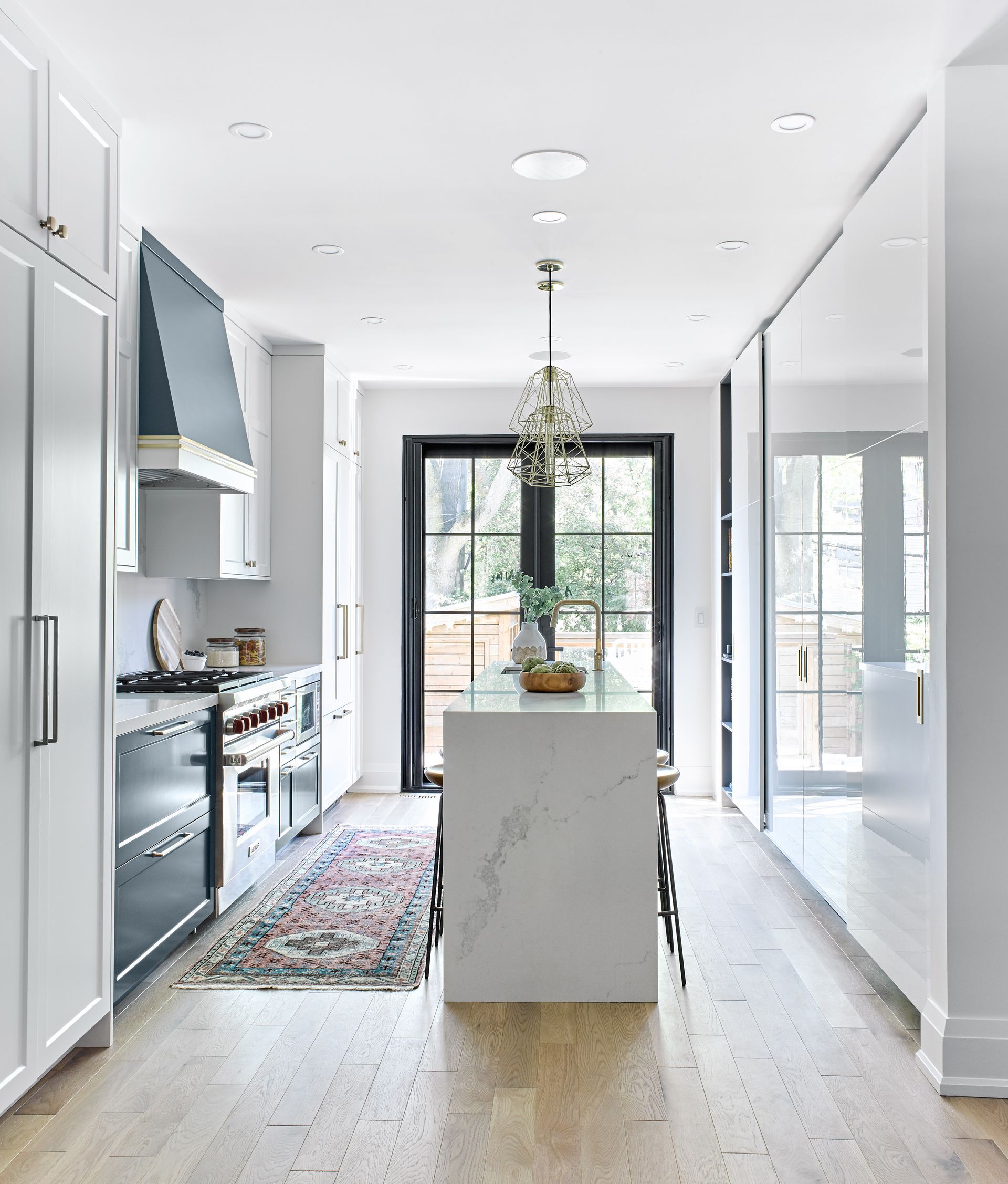 A kitchen with white cabinets and a large island in the middle