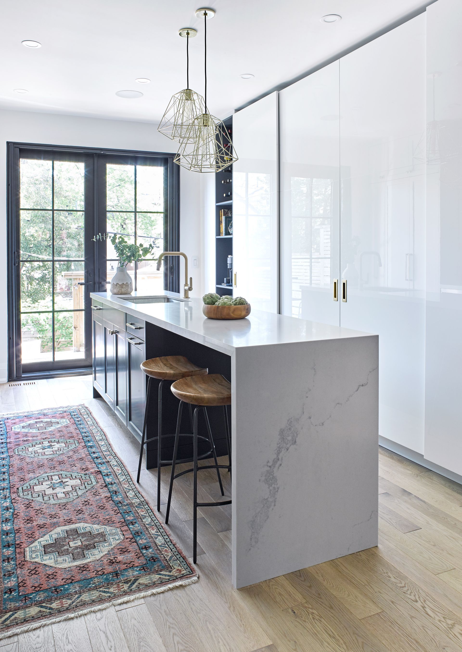 A kitchen with a large island and stools