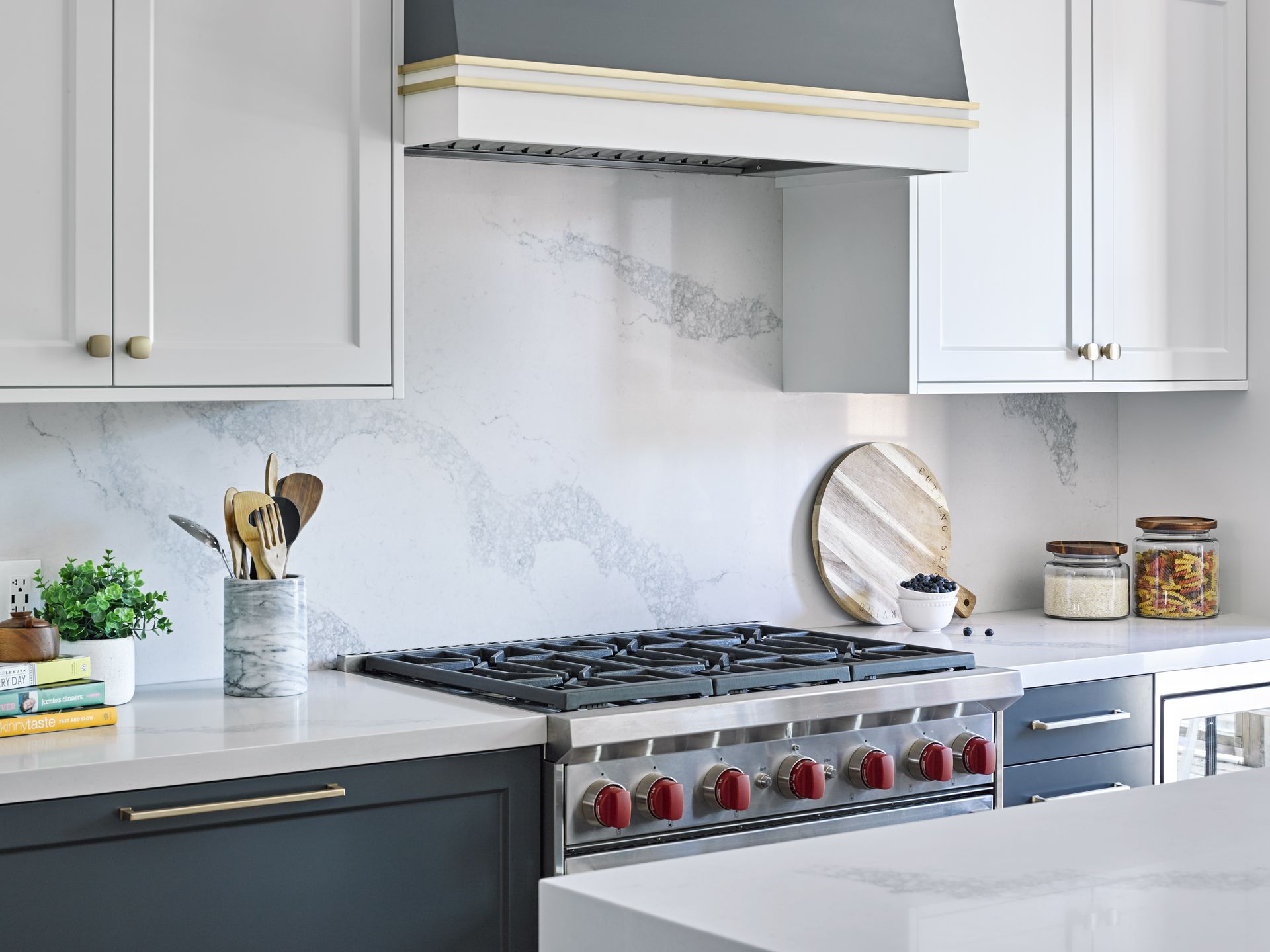 A kitchen with white cabinets , a stove top oven , and a hood.