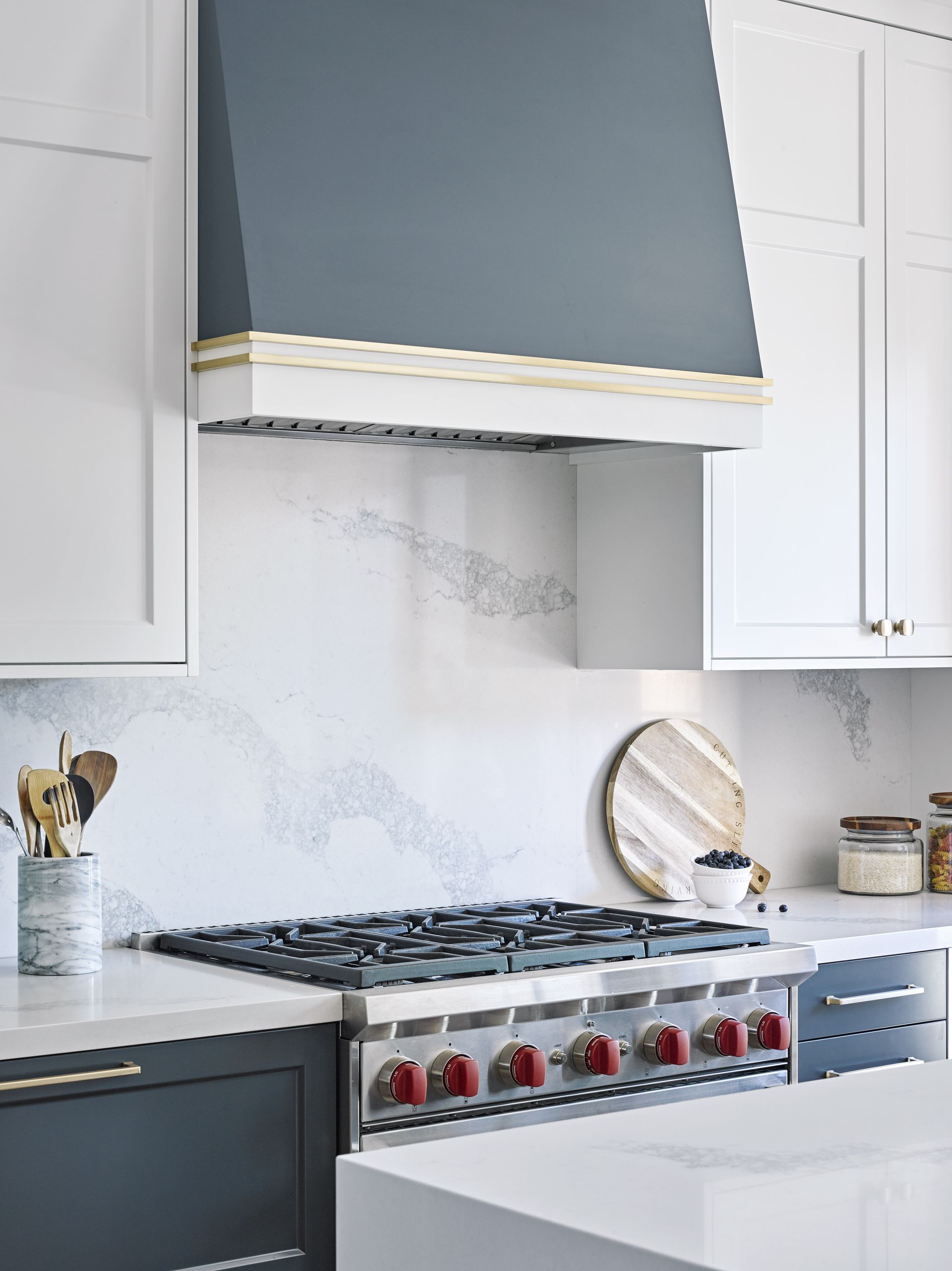 A kitchen with a stove top oven and a hood above it.