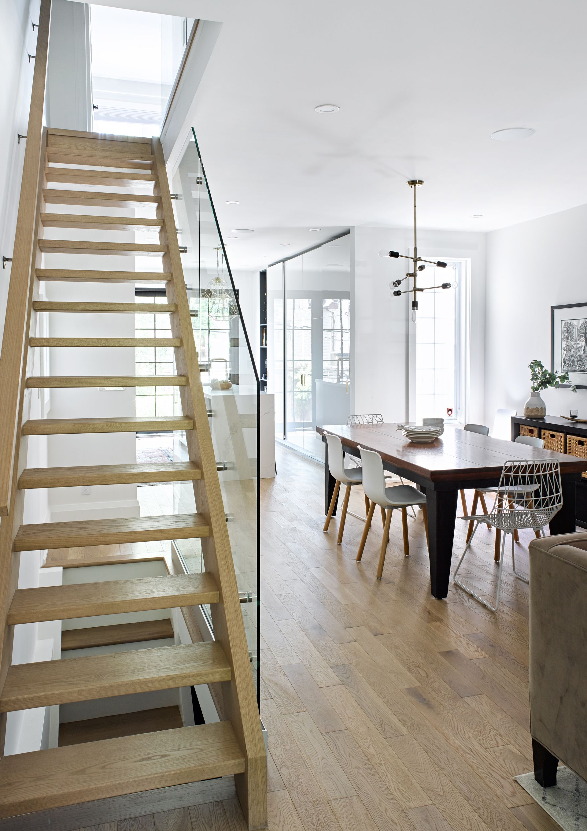 A wooden staircase leading up to a dining room with a table and chairs.
