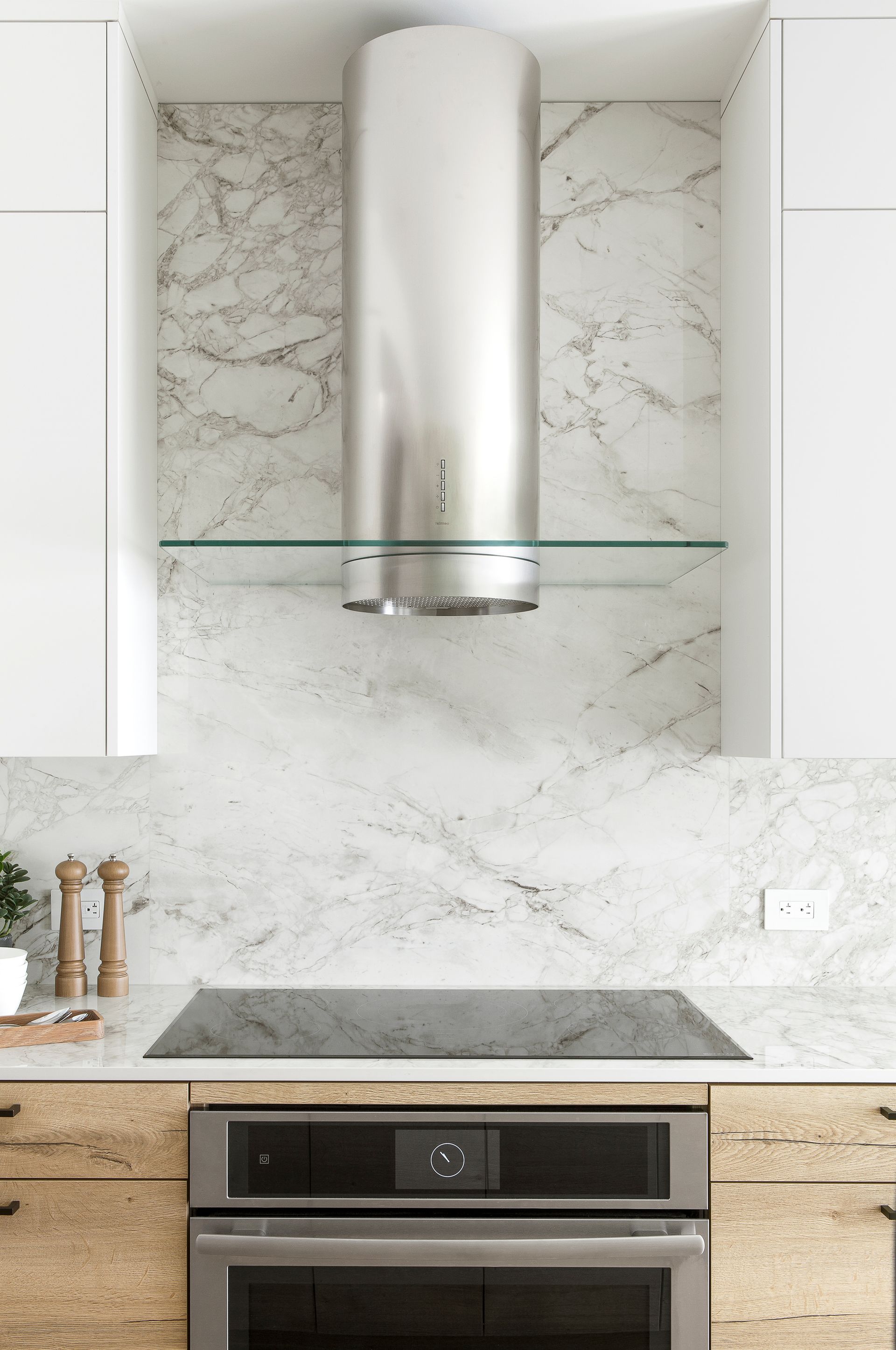 A kitchen with a stainless steel hood above the stove.