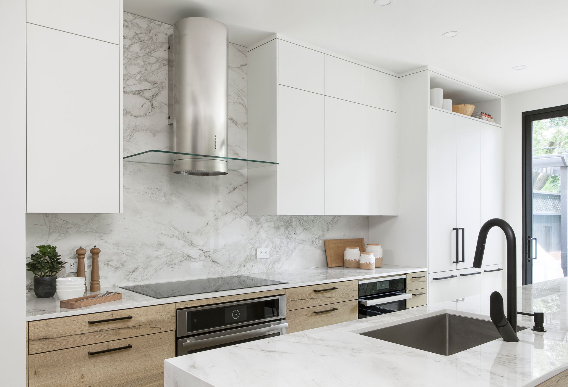 A kitchen with white cabinets , stainless steel appliances , a sink and a stove.