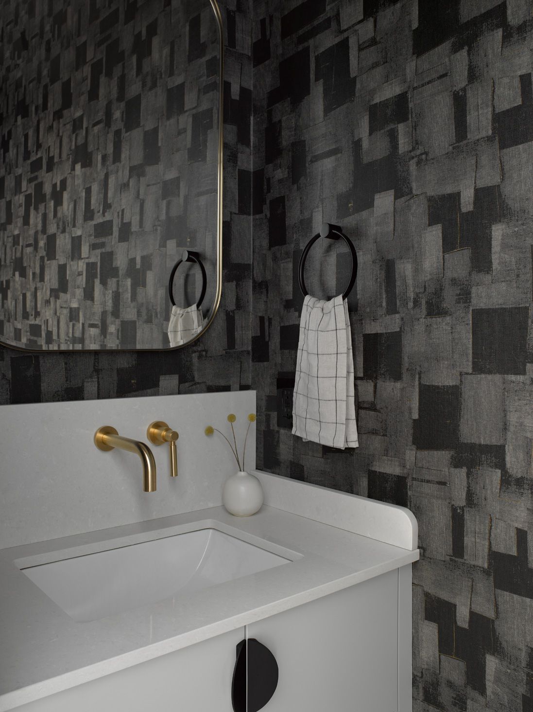 A bathroom with a sink a mirror and a towel hanging on the wall