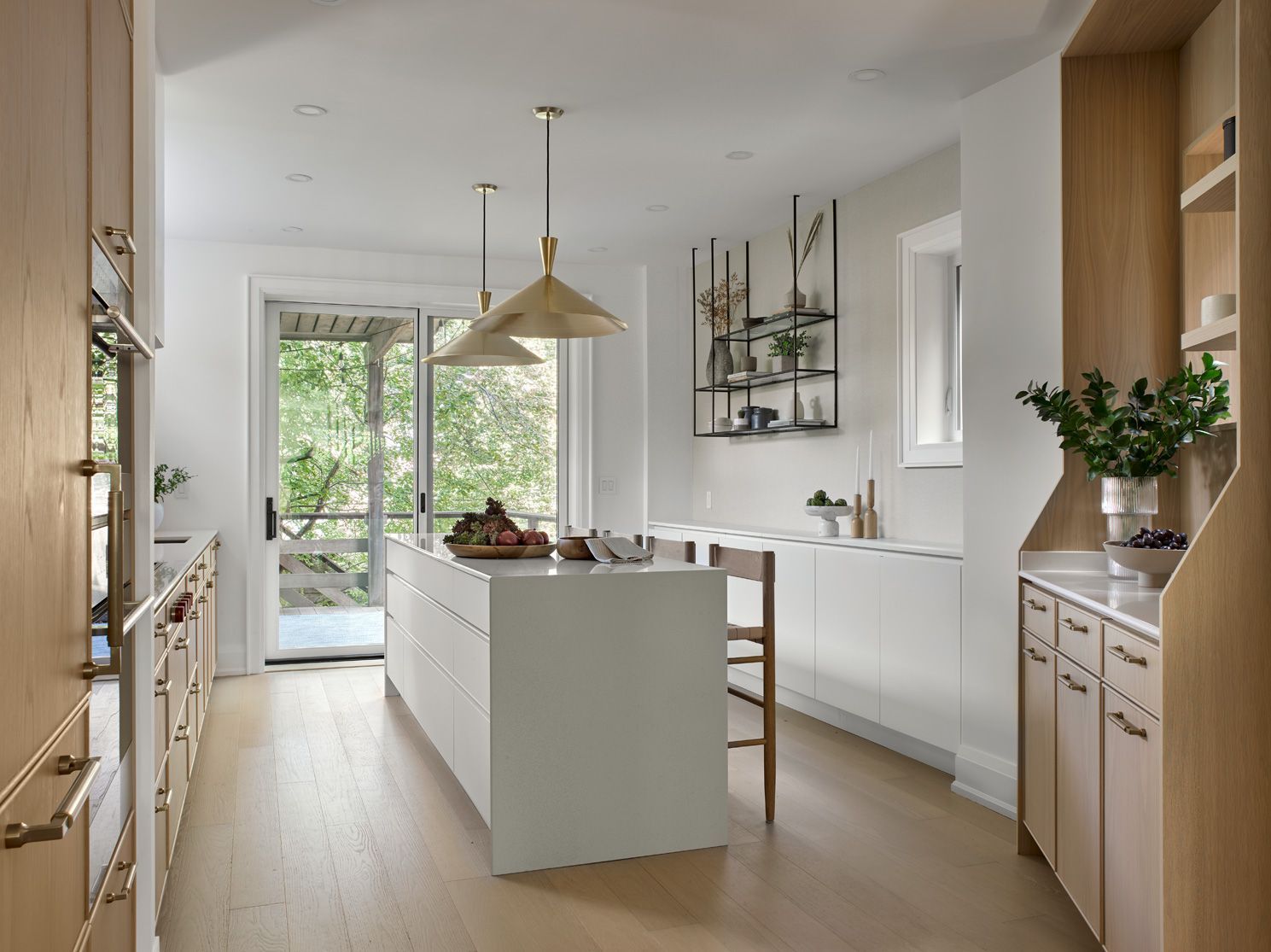 A kitchen with white cabinets and wooden floors and a large island in the middle.