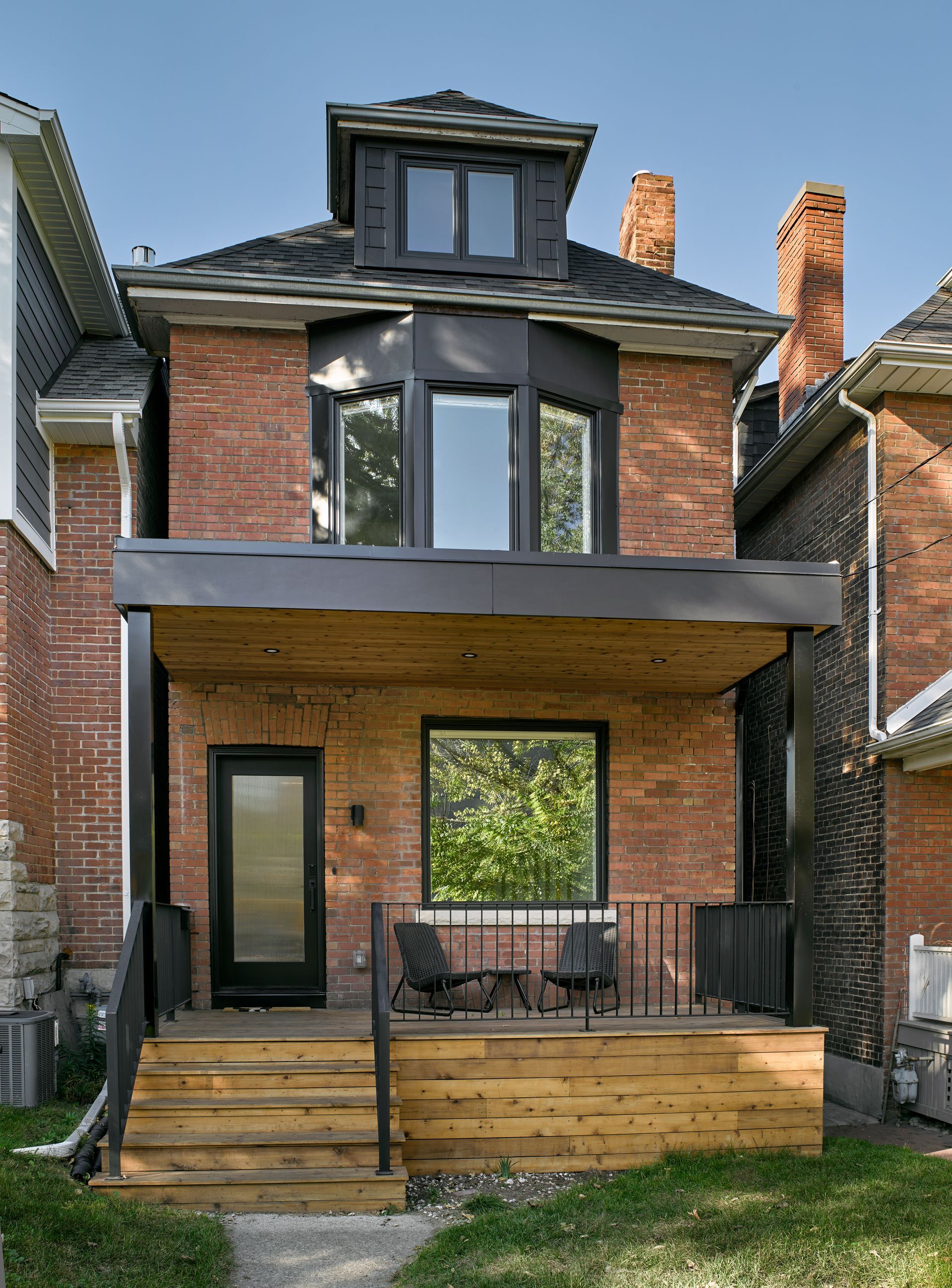 A brick house with a wooden deck and stairs