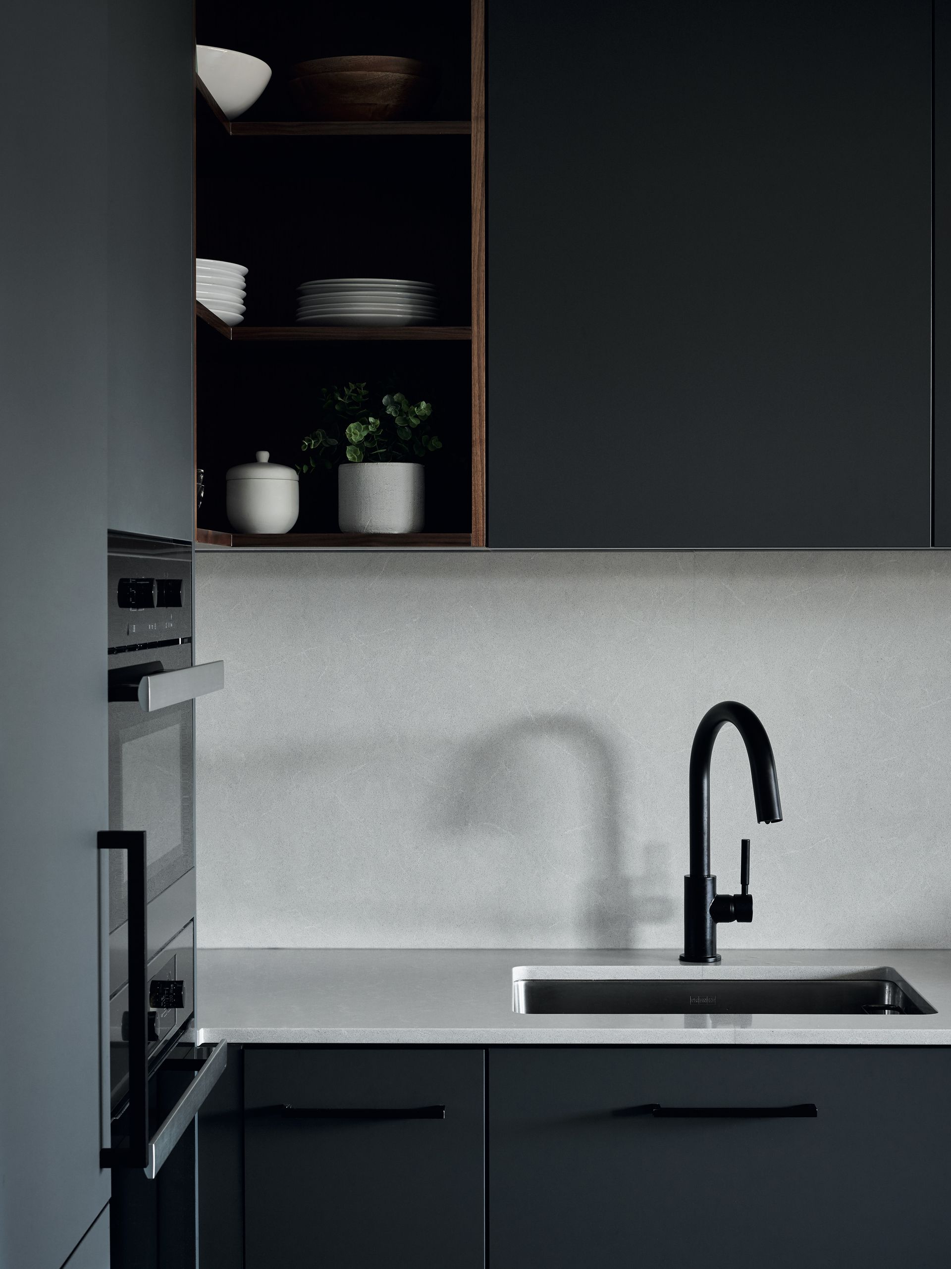 A kitchen with black cabinets and a sink