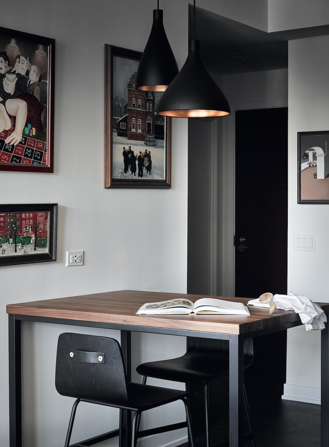 A dining room with a wooden table and black chairs