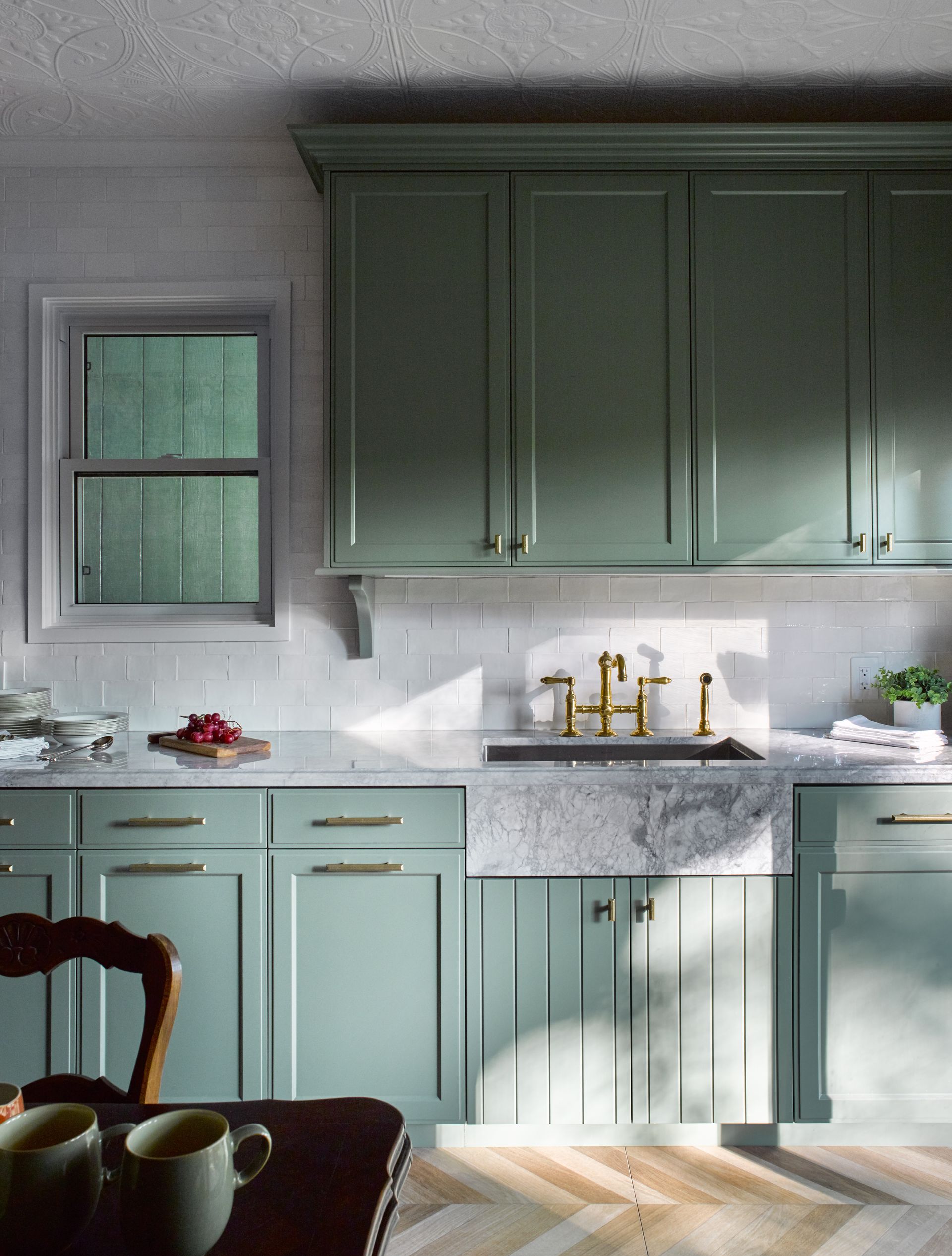 A kitchen with green cabinets and a sink