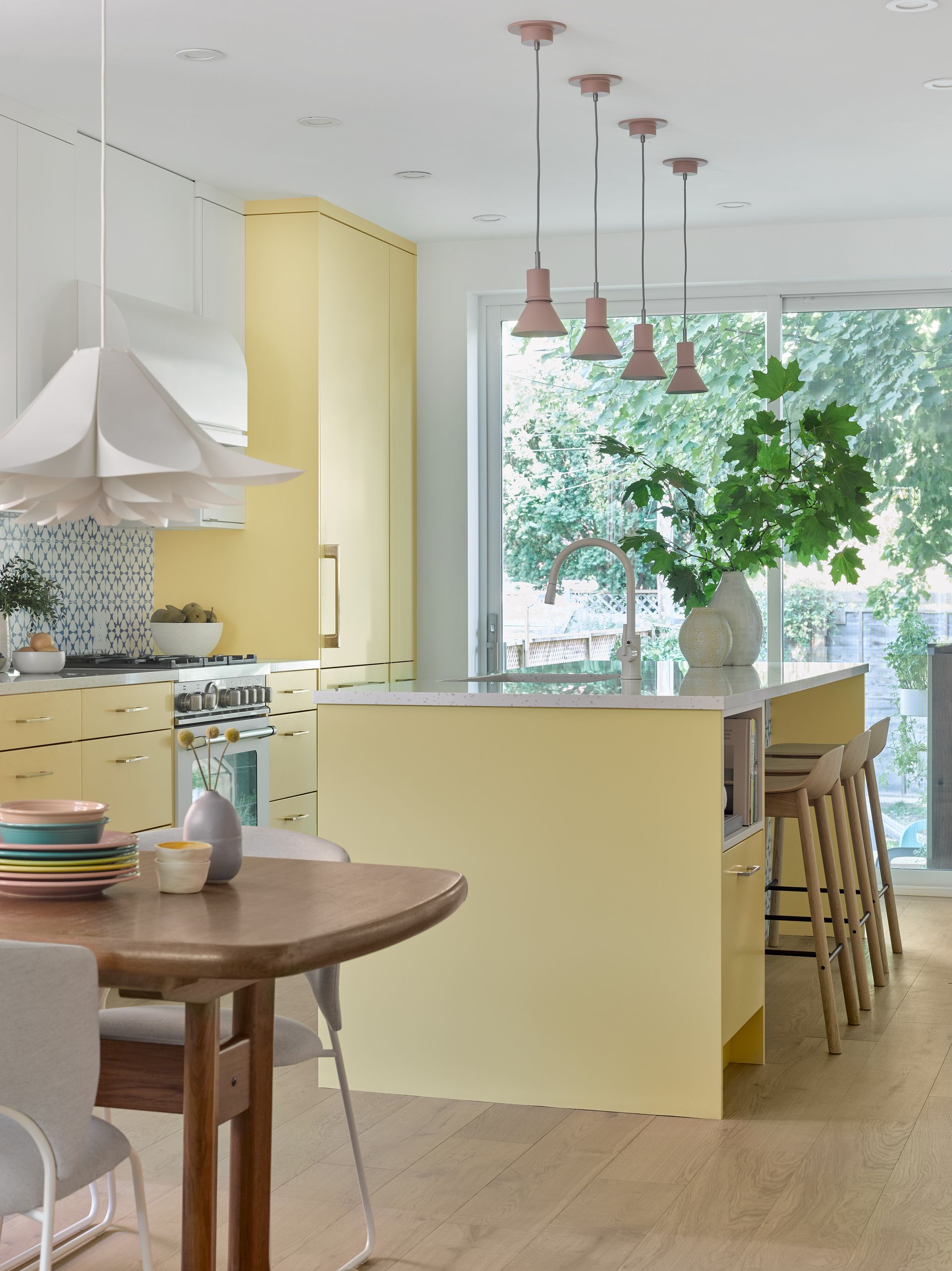 A kitchen with yellow cabinets and a table and chairs