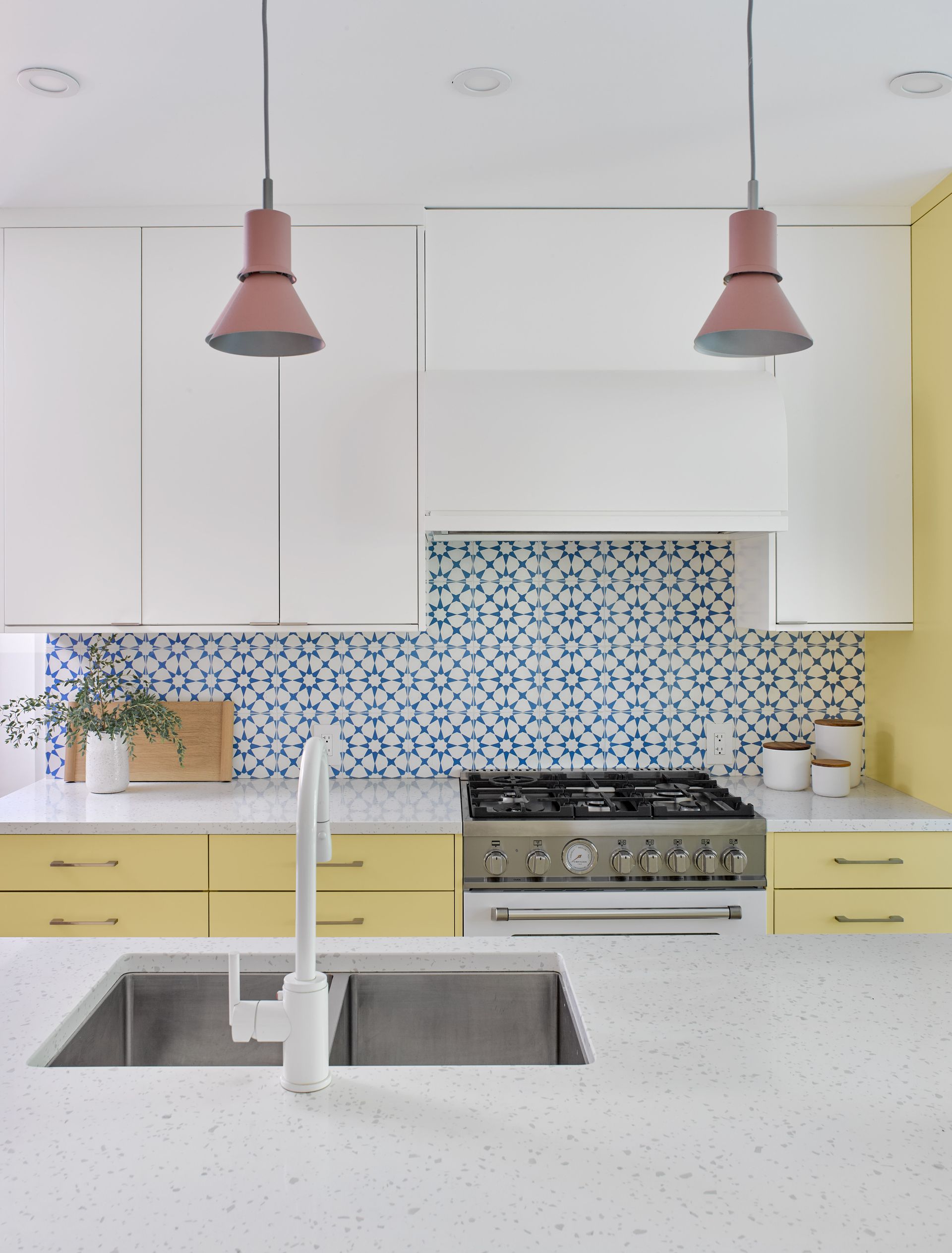A kitchen with two sinks and a stove top oven