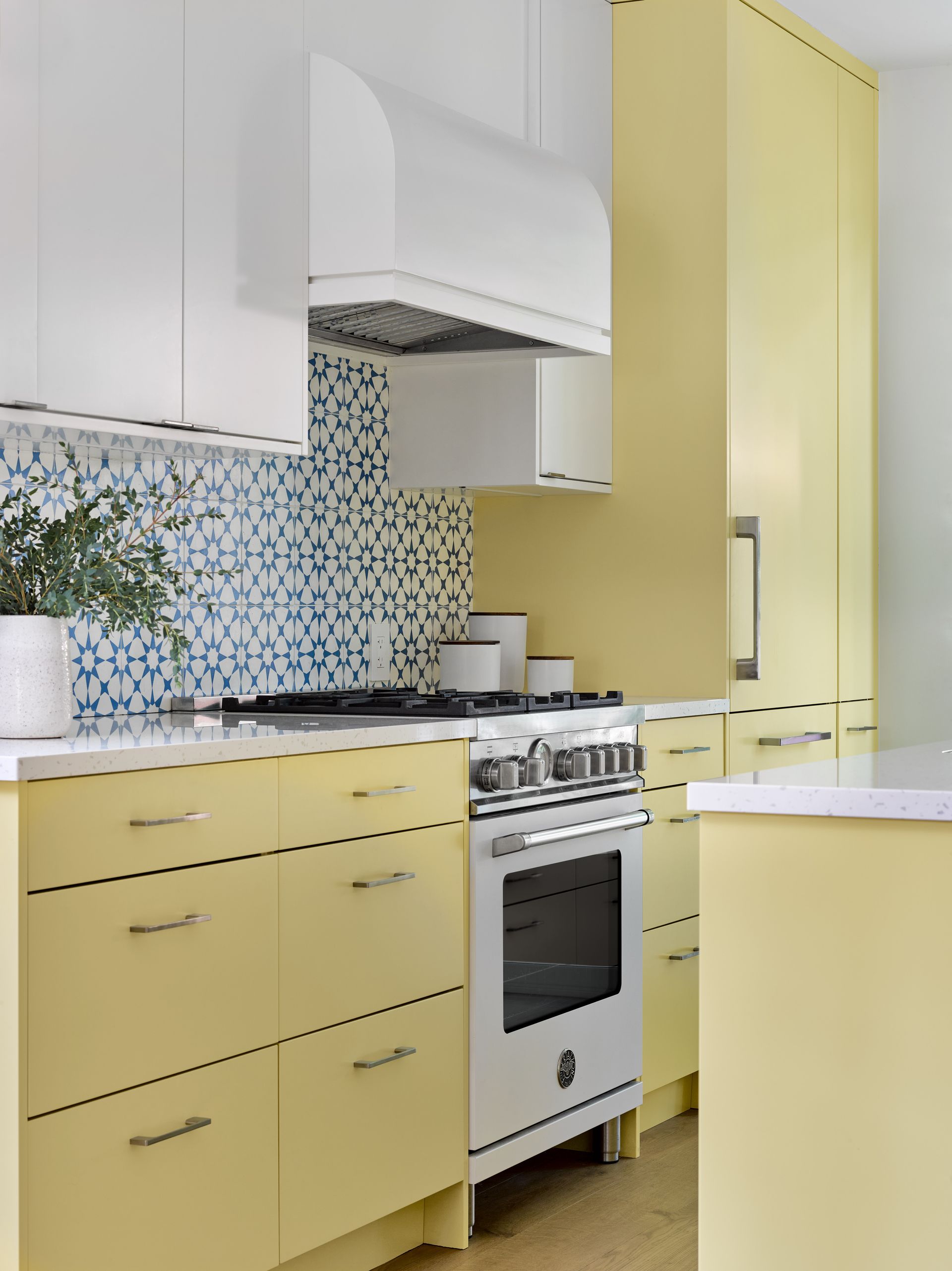 A kitchen with yellow cabinets and white appliances