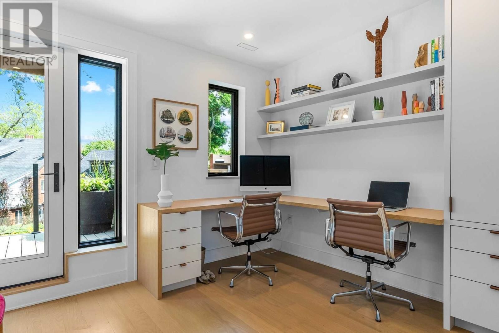 A home office with two desks , two chairs and a computer.