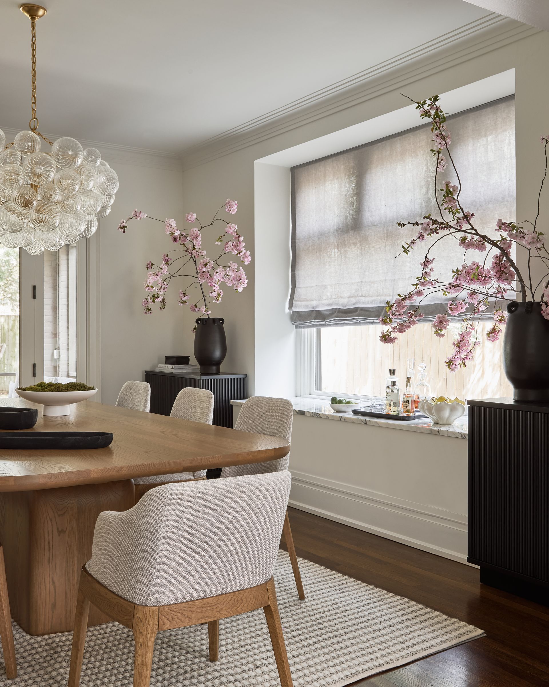 A dining room with a table and chairs and a window.